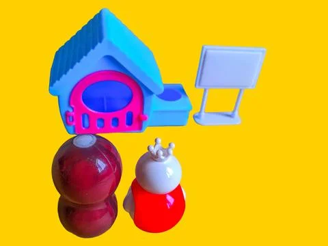 Two toy figures are looking at a toy house and a white toy sign Stock Photos