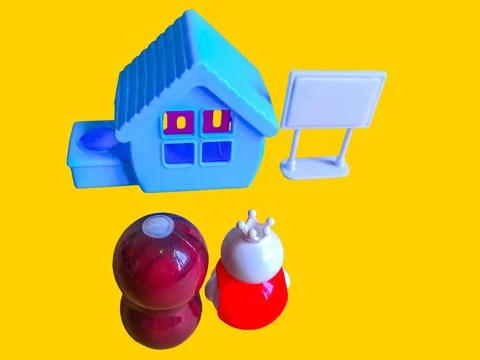Two toy figures are looking at a toy house and a white toy sign Stock Photos