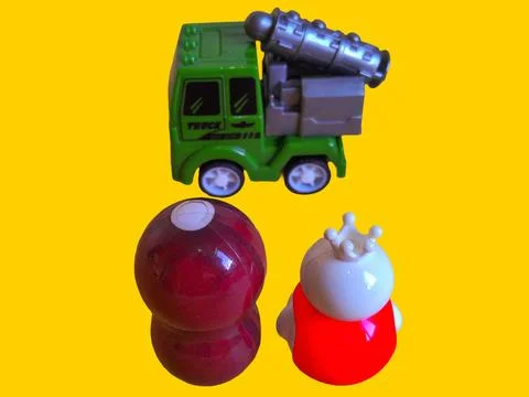 Two toy figures are looking at a military truck with a toy rocket launcher Stock Photos
