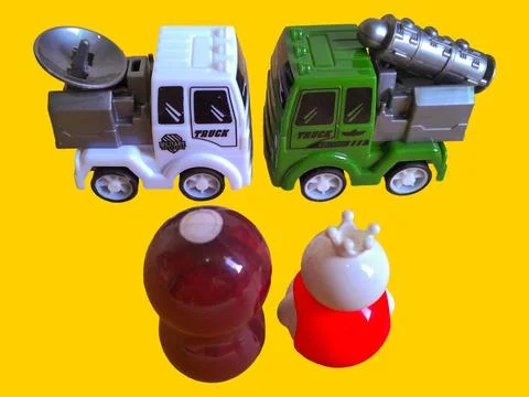 Two toy figures are looking at two toy army trucks Stock Photos