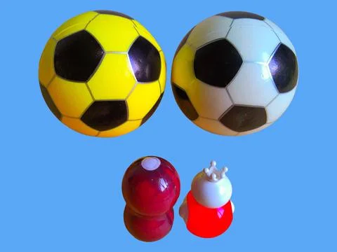 Two toy figures are looking at two soccer balls on a blue background Stock Photos