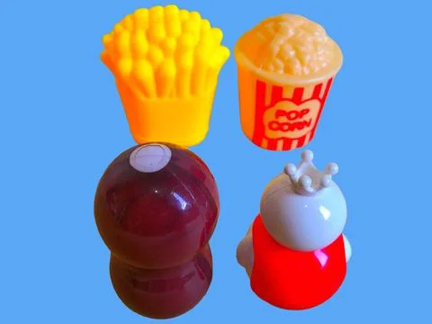 Two toy figures are looking at toy pop corn and toy french fries Stock Photos