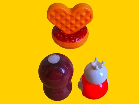 Two toy figures are looking at a toy donut and a love-shaped toy wafer Stock Photos