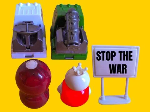 Two toy figures are looking at two army trucks and the words stop the war Stock Photos