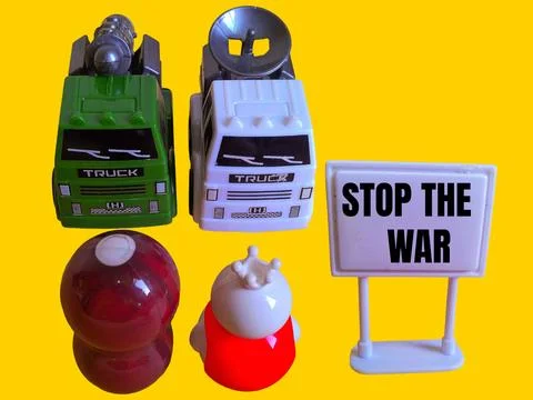 Two toy figures are looking at two army trucks and the words stop the war Stock Photos
