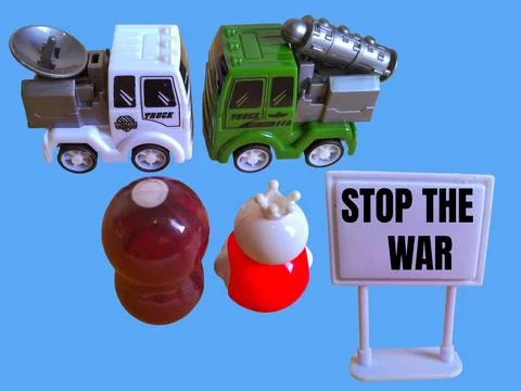 Two toy figures are looking at two army trucks and the words stop the war Stock Photos