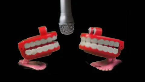 Two toy joke sets of chatty teeth chattering or singing into a microphone. Stock Footage 239643914