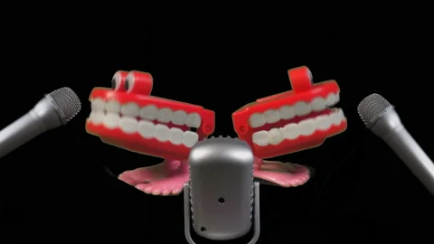 Two toy joke sets of chatty teeth chattering or singing into microphones. Stock Footage 239644035
