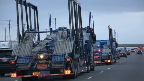 Two tractor units with a car carrier trailer on QEW highway in Ontario Vídeos de archivo 103065071