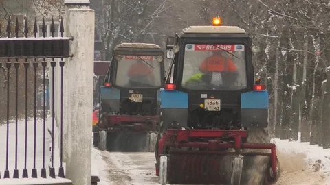 Two tractors clear the sidewalk of snow Stock Footage 123166508