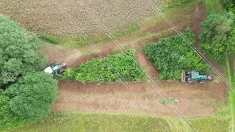 Two tractors clearing bushes under a high-voltage power line Stock-Footage 270769541