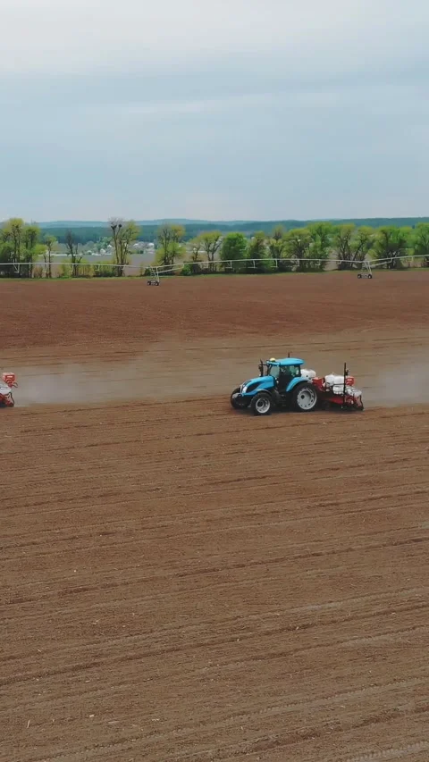 Two tractors in the field with special precision planters, corn is planted, or Stock Footage 314657402