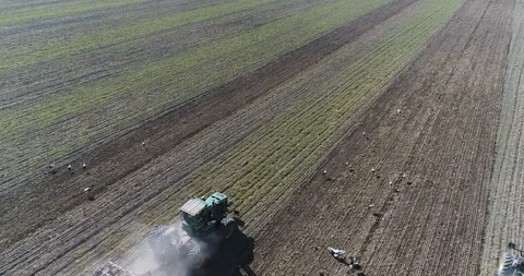 Two tractors going in the opposite direction and cultivating land with using an Stock Footage 123780103