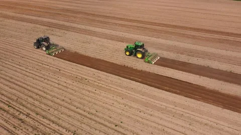 Two tractors hilling potatoes, creating combs on potato field, aerial view Stock Footage 245214081