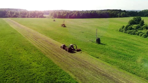 Two Tractors With Mower And Trailer Mow Clover In The Field (2) Stock Footage 128079239