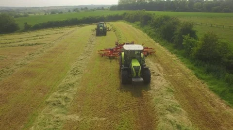 Two tractors pass underneath in British countryside Stock Footage 64764214