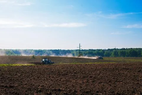 Two tractors plowing field in spring Stock Photos