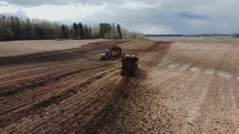 Two Tractors with trailers Spreading Organic Manure on Farm Field Stock Footage 153010624