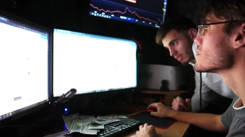 Two traders engaged in cryptocurrency analysis, focused on multiple screens Stock Footage 318211912