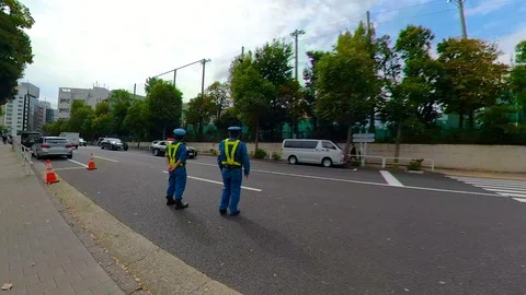 Two traffic aides on the side of the road in Tokyo Japan Stock Footage 129279955