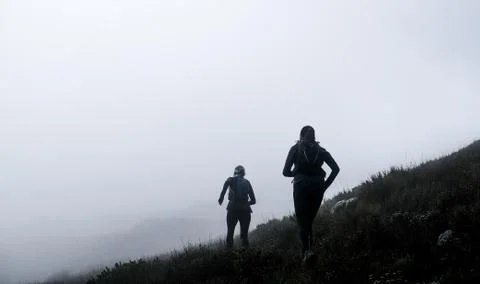 Two trail runners high up on on a mountain with mist Stock Photos