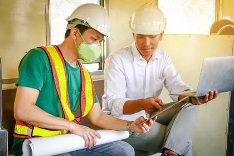 Two train engineers wore a white hat. Stock Photos