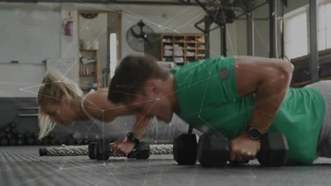Two trainees starting kneeling on hex dumbbells, doing push-ups then alternating Stock Footage 331045437