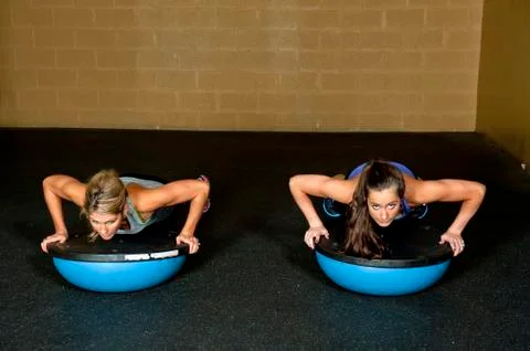 Two Trainers On Bosu Ball Doing Push Up Stock Photos