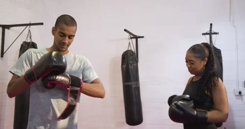 Two training partners adjusting gloves and wraps before shadow sparring on pink Stock Footage 342492118