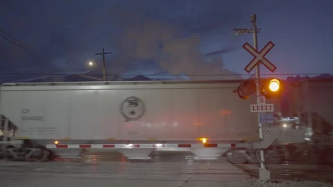 Two trains crossing each other by flashing railway lights at night Stock Footage 225406736