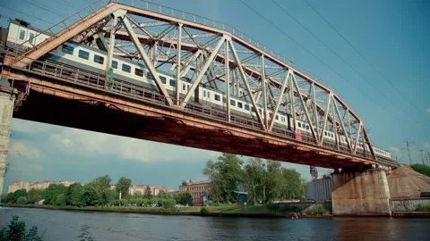 Two trains move on railway bridge, motor boat floats on river under the bridge Stock Footage 157283318