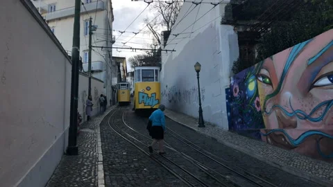 Two Trams Crossing Each Other in a Narrow Street with Graffiti Stock Footage 139452357