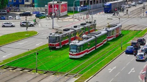 Two trams going through a busy main street over vibrate green grass Stock Photos