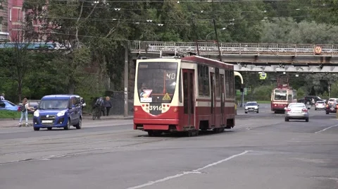 Two trams meet in mixed traffic under railway viaduct at Serdobolskaya Street Stock Footage 67468226