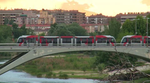 Two tramways meet over the bridge with background sunset sky Stock Footage 38716991