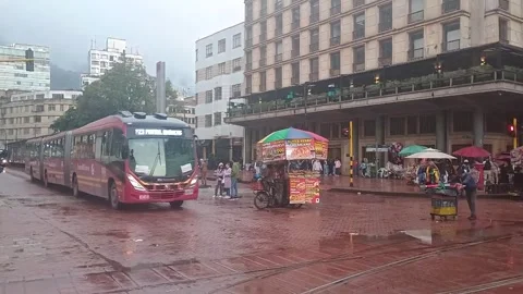 Two TransMilenio buses passing through Jimenez Avenue in downtown Bogota Stock Footage 309704794