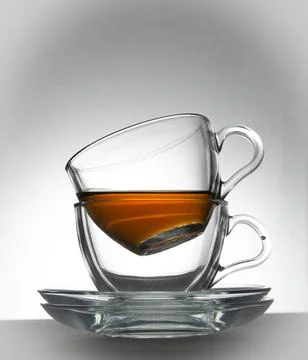Two transparent cups and two transparent saucers on a white background Stock Photos