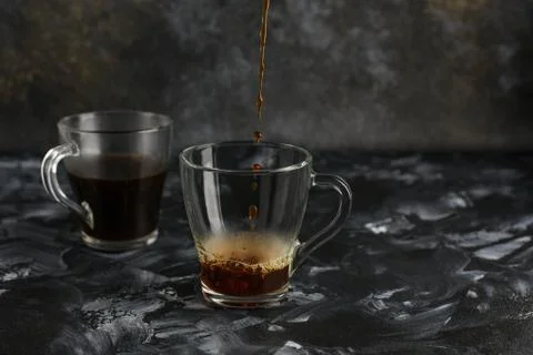 Two transparent cups of coffee on a dark background. Stock-Fotos