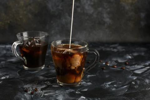 Two transparent cups of cold coffee with milk. Iced coffee. Stock Photos