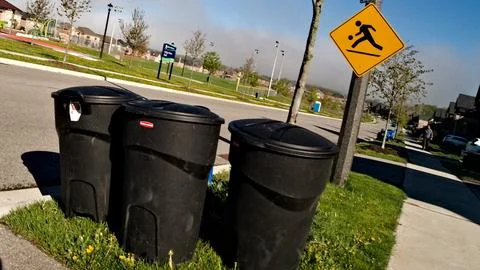 Two Trash Cans Alongside Road Stock Photos