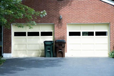 Two trash cans in front of house Stock Photos