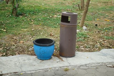 Two trash cans made of rubber and metal in a city park Stock Photos