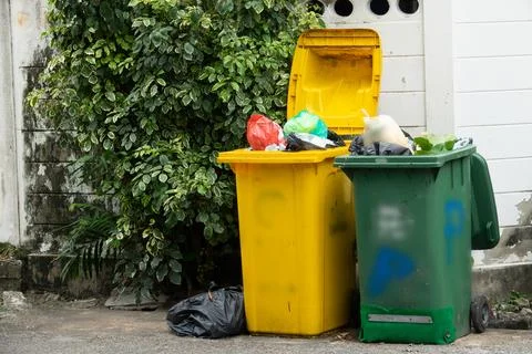 Two trash cans, one yellow and one green Stock Photos