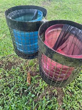 Two trash cans in a park Stock Photos