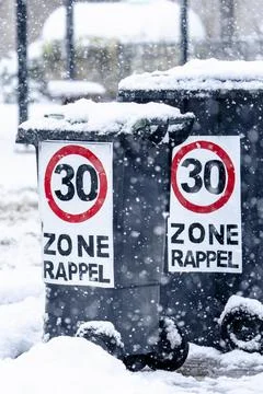 Two trash cans with a red and white sign on them that says 30 zone rapel Stock Photos