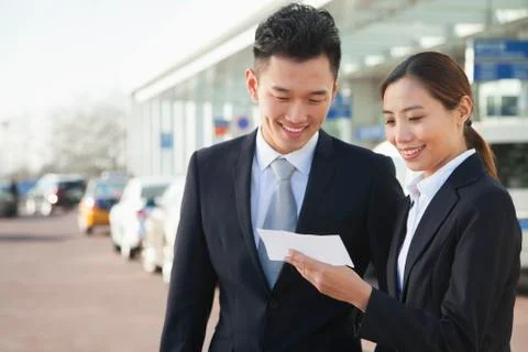 Two travelers looking at ticket in airport Stock Photos