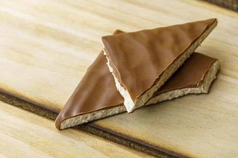Two triangular pieces of chocolate with white filling inside. Stock Photos