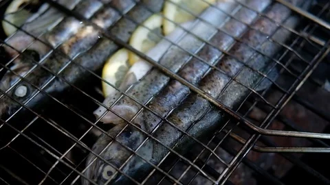 Two trouts filled with lemons on a grill 動画素材 77299258