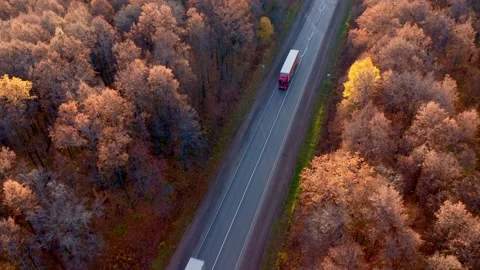 Two trucks with long trailers drive out of town on a cloudy day. Delivery Stock Footage 163692843