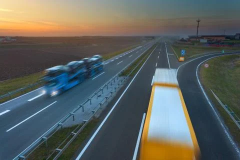 Two trucks in motion blur on the freeway at sunset 写真素材